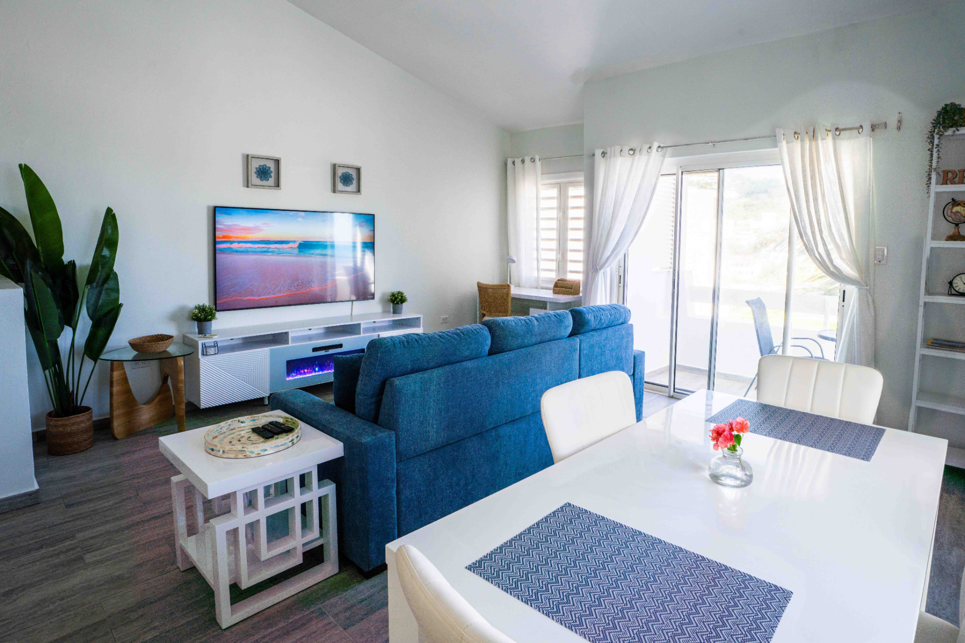 Open living and dining area with blue sofa and terrace doors